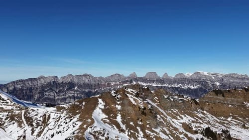 Snowy alpine ridge with distant mountain peaks