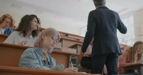 Universitätsprofessor hält Vorlesung vor einer Gruppe von Männern und Frauen, während junge Leute zuhören und