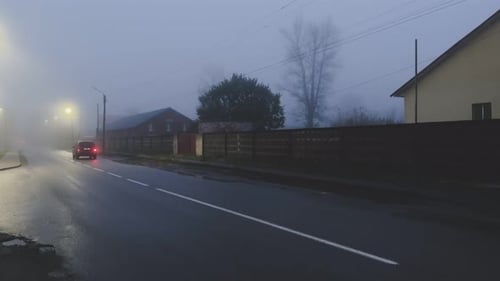 The Car is Driving on the Road in the Fog at Night