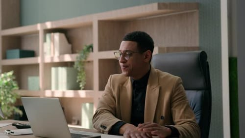 Man Frustrated at Desk with Laptop in Office