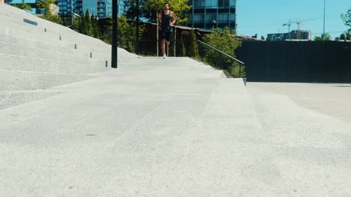 Man Jogging Down Concrete Steps in Urban Environment