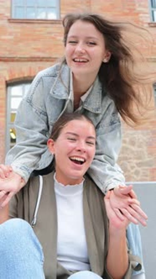 Two Young Women Laughing and Posing Together Outdoors