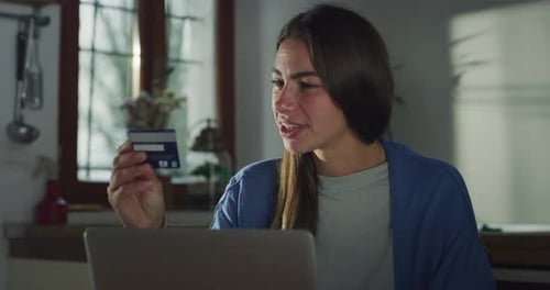 Joven mujer atractiva que usa una computadora portátil para pagar compras o servicios con