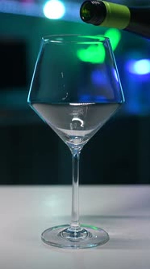 White Wine Pouring into Glass at Night