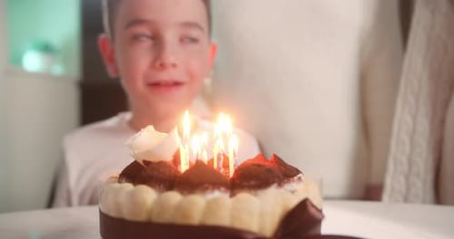 Boy Blowing Out Birthday Candles on Cake
