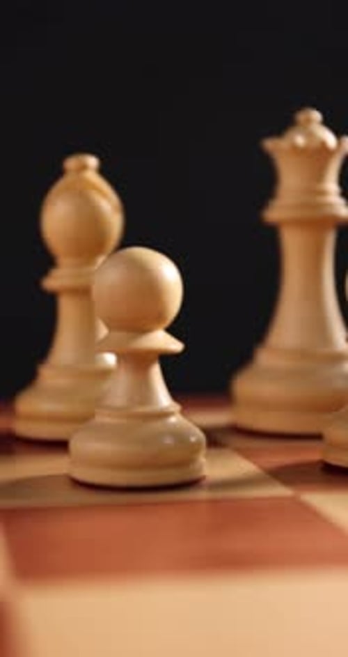 Mann legt Schachfiguren auf das Spielbrett, Nahaufnahme. Kamera bewegt sich nach links