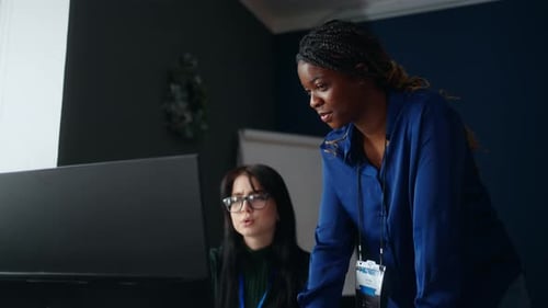 Black and Caucasian Women Working Together in Office Portrait of Female Colleagues at Computer