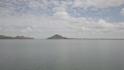 Ocean with the bright sky with hills in the background. Drone view of the shore.
