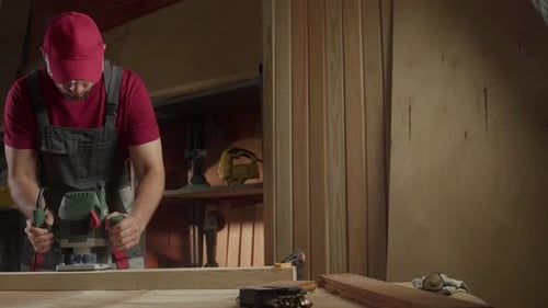 A Skilled Worker is Using a Milling Machine in a Cozy Workshop Surrounded By Wooden Materials and