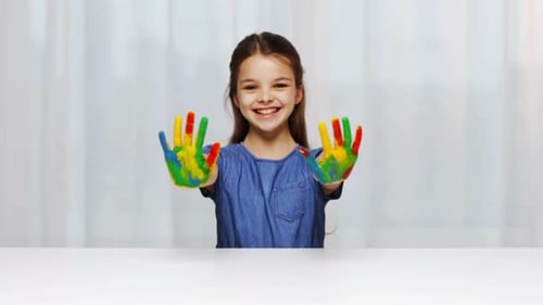 Education, School, Creativity, Art And Painting Concept - Smiling Little Student Girl Showing Pai...