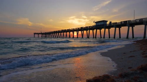 Venice Fishing Pier in Florida at Sunset Evening Seascape with Surf Waves Crashing on Sandy Beach
