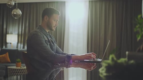 Man working on laptop at glass table