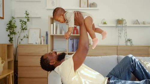 Affectionate Father Plays with Baby Daughter at Home
