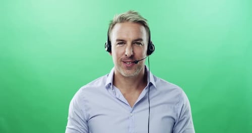 4k video footage of a mature man using a headset against a green studio background