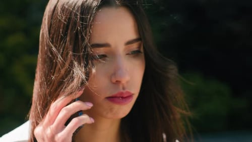 Worried Woman Talking on Phone Outdoors