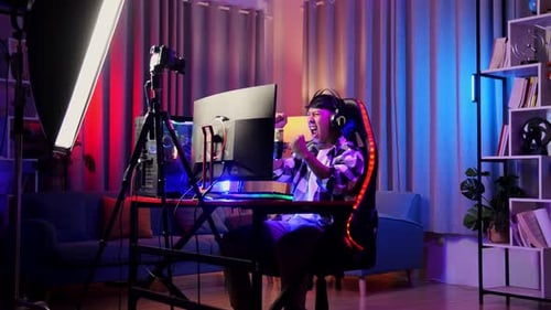 Asian Boy Streamer Celebrating Winning Game On Computer. Live Stream Video Game