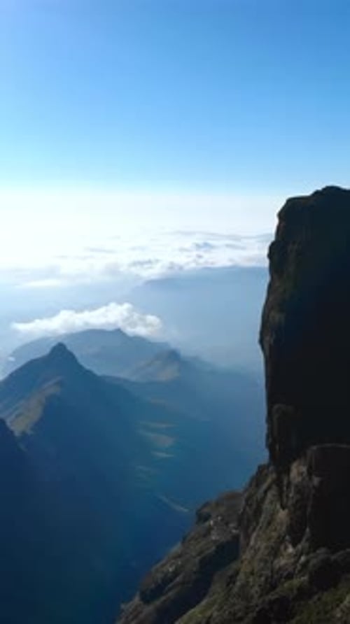 Valley with Low Clouds Aerial View of Foggy Valley with Dawn Illumination on Rugged Mountain Edges