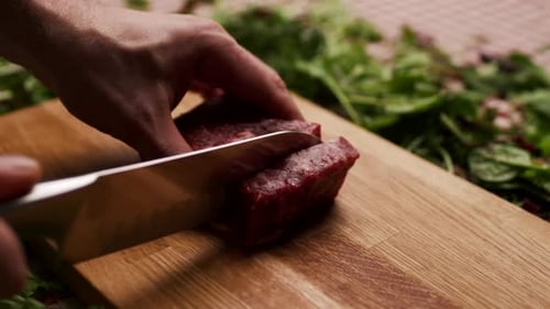 Cutting Raw Beef Steak on Wooden Board