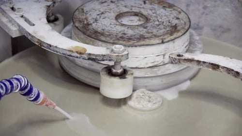 Close up of a white, spinning art polisher installation