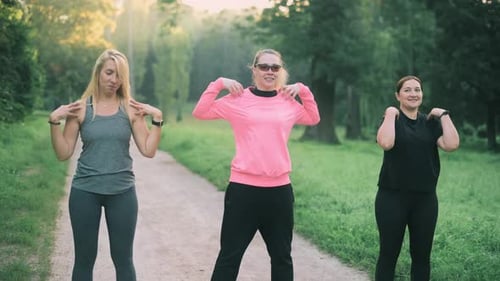 Women Exercising and Stretching in Park Together