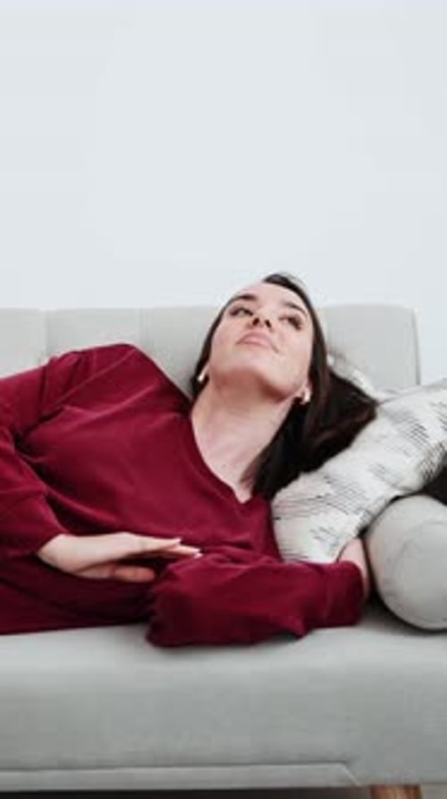 Young Woman Relaxing on Sofa at Home