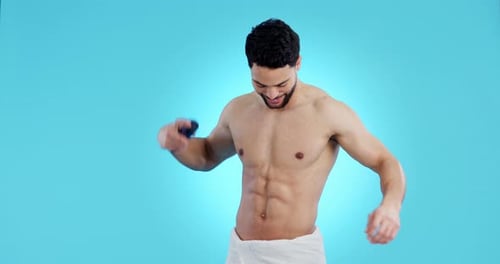 Smiling Shirtless Man Sprays Deodorant in Studio
