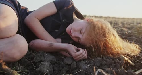 Woman Lies on Soil at Sunset