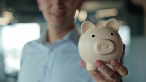 Businessman Holding a Piggy Bank