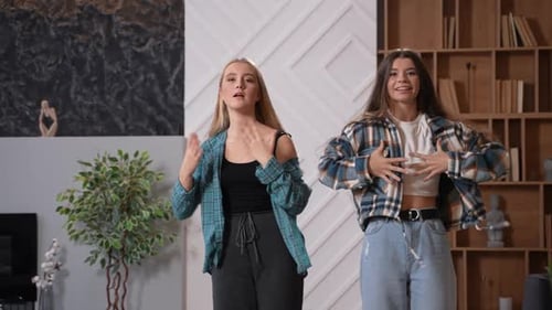 Two Young Women Enjoy Dancing Together at Home