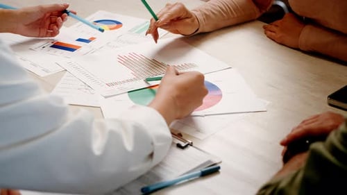 Gruppe von Kollegen arbeitet an Dokumenten, die Statistik studieren