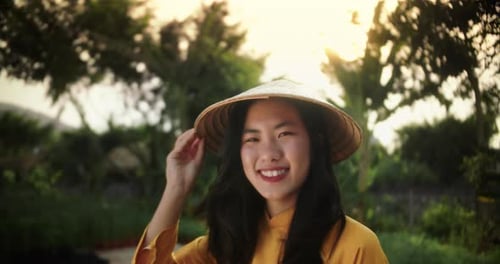 Smiling Woman in Traditional Hat at Sunset