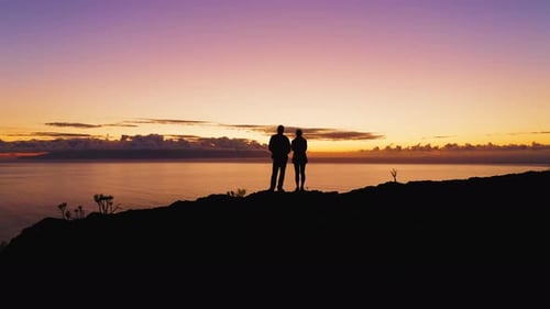 Couple Silhouette Man and Woman Two Tourists Stand on the Top of Mountain During Colorful Sunset