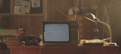 Vintage Television with Static on Desk in Room