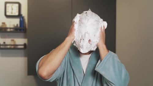 portrait of a crazy man smearing foam on his face and laughing