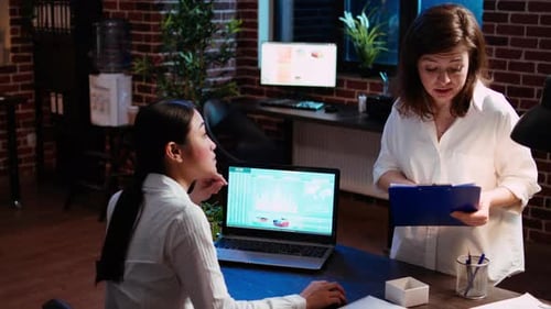 Two Women Analyzing Data in Modern Office