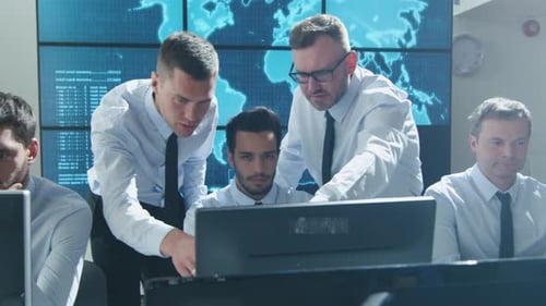 Team-IT-Sicherheitsexperte arbeitet in einem hellen Überwachungsraum voller Displays