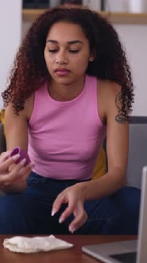 Latin American Teenage Girl Browsing Menstrual Cup Instructions on Laptop