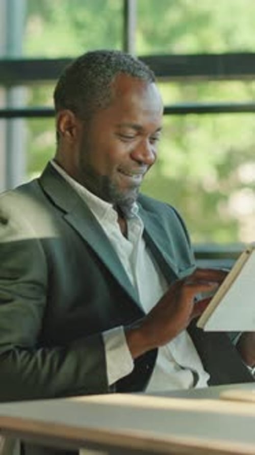 Man in Suit Using Tablet at Desk Indoors