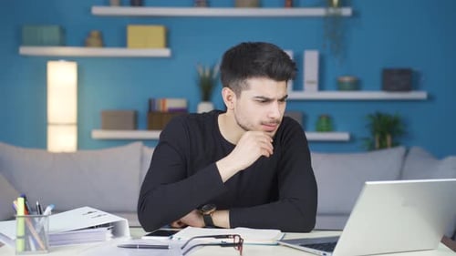 Serious and focused working man thinks in front of what he sees on the screen.