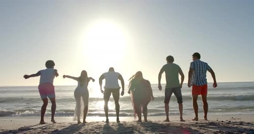 Diverse group of friends jump in joy on a sunny beach