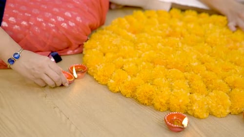 Decorating Colorful Diwali Rangoli with Flowers and Diyas