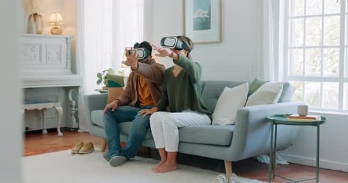 Couple Wearing VR Headsets on Living Room Sofa