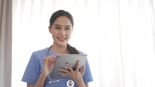 Female health care worker is using digital tablet.