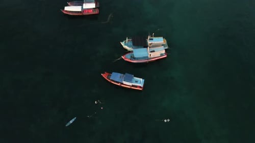 Blick auf einen paradiesischen Strand mit vielen Fischerbooten in Thailand