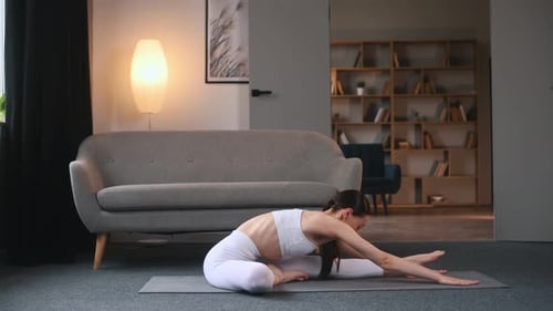Exercise for the spine. Young woman with slim body type doing yoga at home