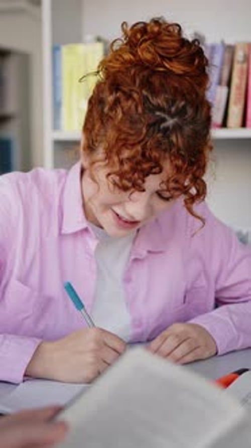 Engaged Student Studying and Writing Indoors at Desk