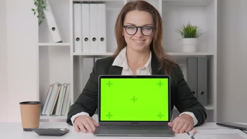 Business Woman at Desk with Green Screen Laptop