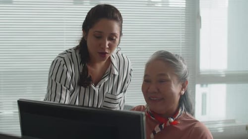 Women Collaborating on Computer in Modern Office