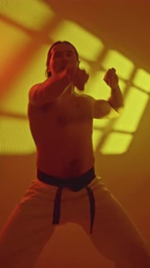 Strong Man Practicing Karate in Red Lit Room