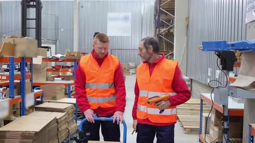 Lagerarbeiter diskutieren mit Barcodescanner über Logistik